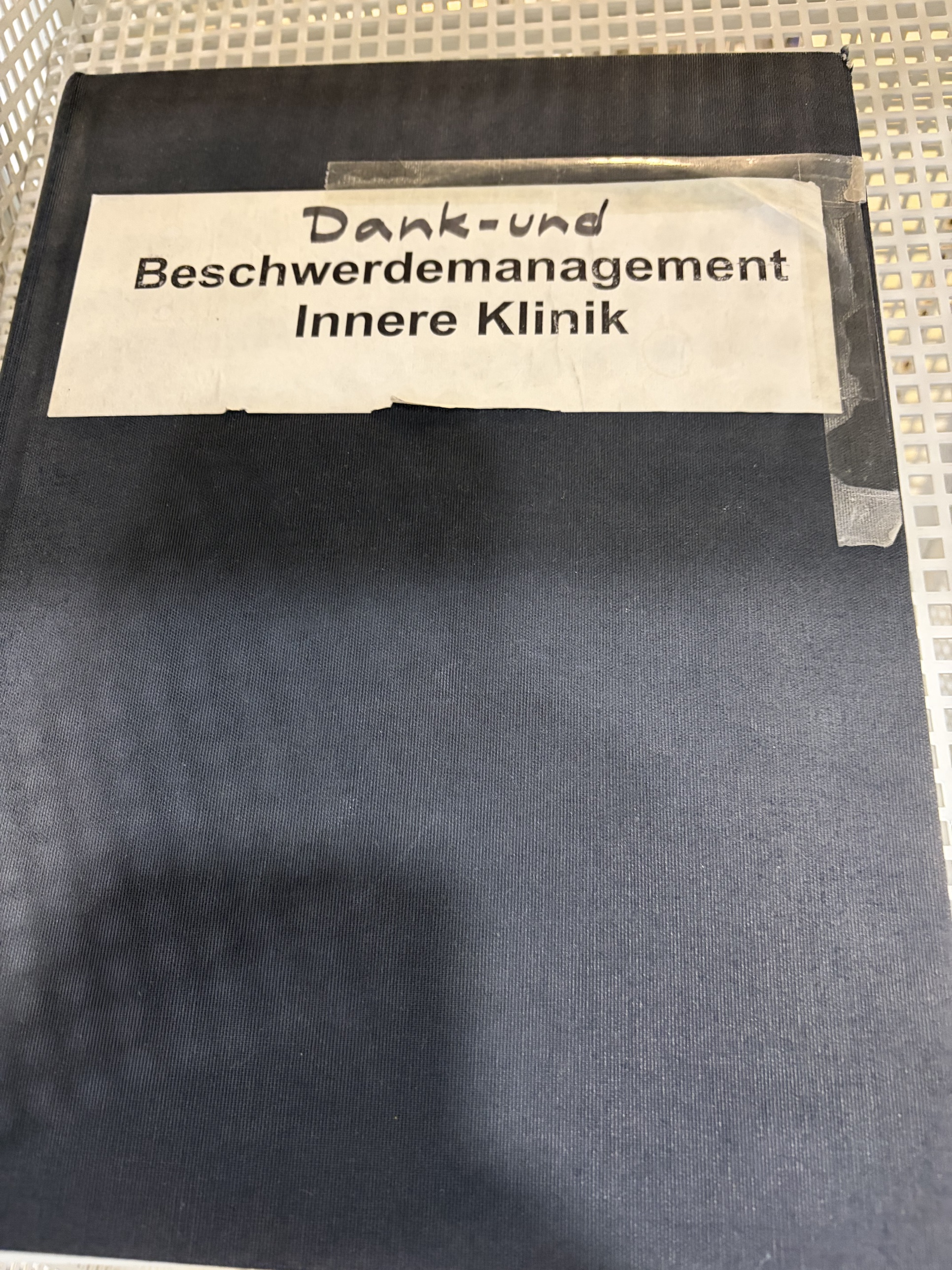Heft mit der Aufschrift 'Dank- und Beschwerdemanagement Innere Klinik' im Wartebereich der Charité, wobei 'Dank- und' handschriftlich ergänzt wurde