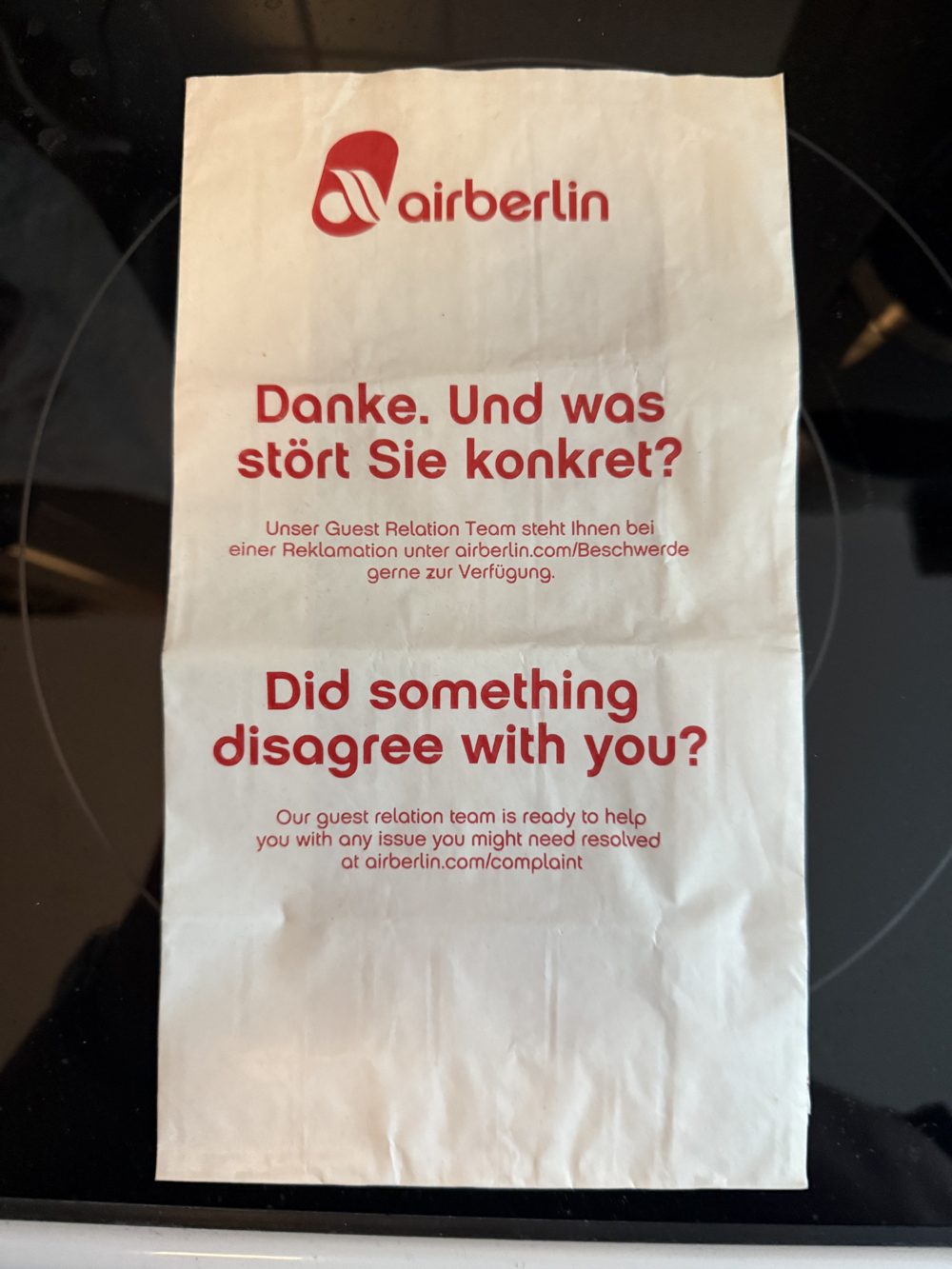 Air-Berlin-Kotztüte mit dem Aufdruck 'Danke. Und was stört Sie konkret?' und 'Did something disagree with you?'